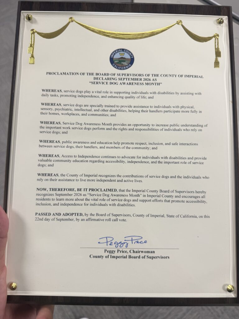 Framed proclamation plaque from the Imperial County Board of Supervisors declaring September 2026 Service Dog Awareness Month. The Imperial County seal sits beneath a gold drape, and the proclamation is signed by Board Chairwoman Peggy Price.